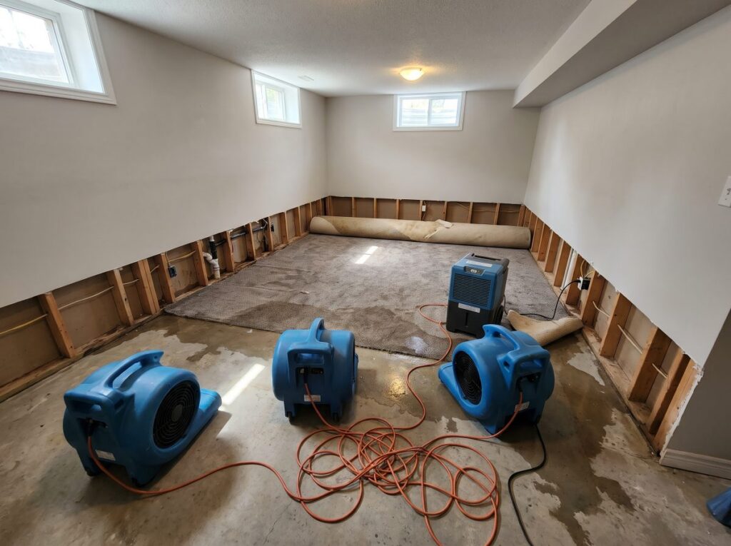 Basement water damage drying with air movers and a dehumidifier after flood cut